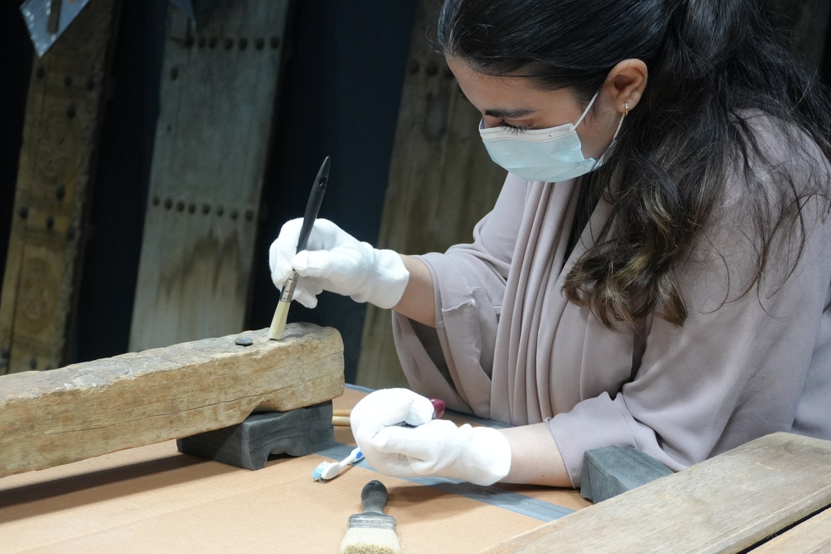 A historic door is cleaned for Wooden Doors of Qatar. Image courtesy of Qatar Museums.
